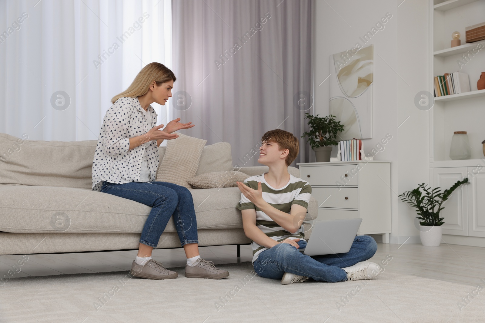 Photo of Mother scolding her teenage son at home