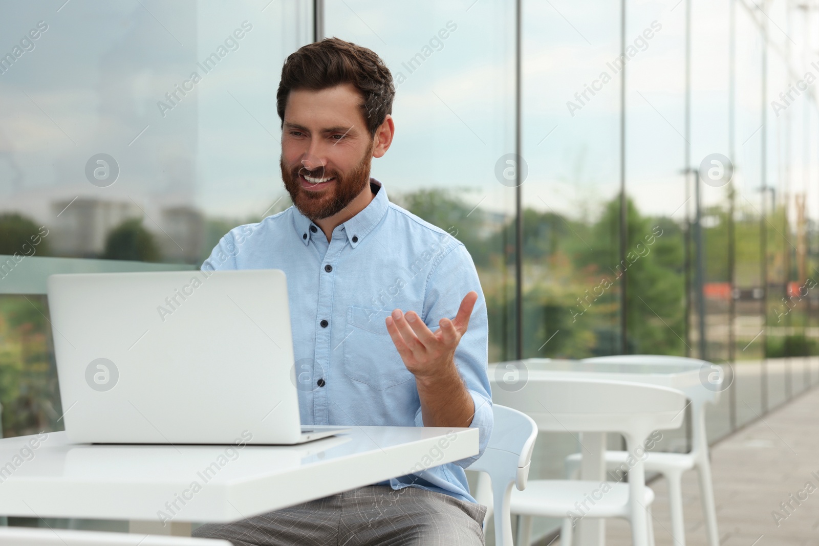 Photo of Handsome man with laptop in outdoor cafe