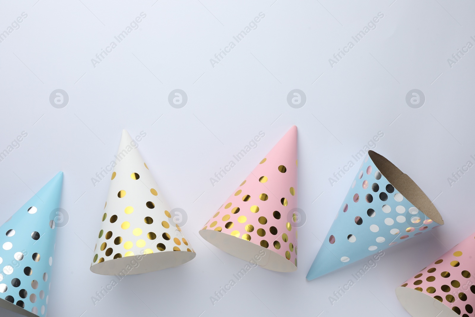 Photo of Beautiful party hats on light background, top view