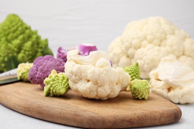 Photo of Various cauliflower cabbages on light grey table
