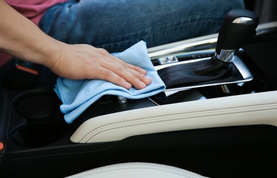 Photo of Man washing car salon with rag, closeup