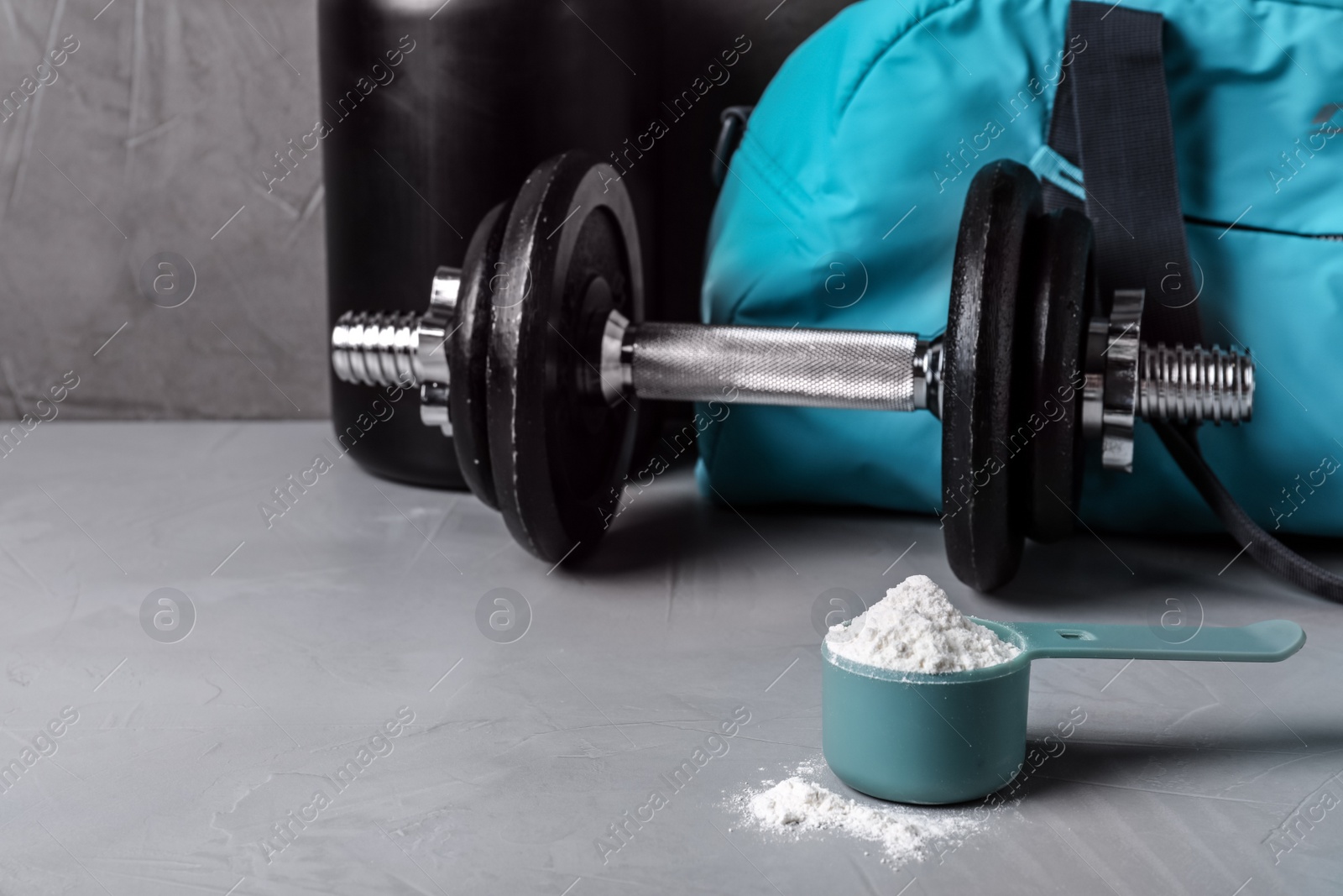 Photo of Composition with protein powder and dumbbell on table. Space for text