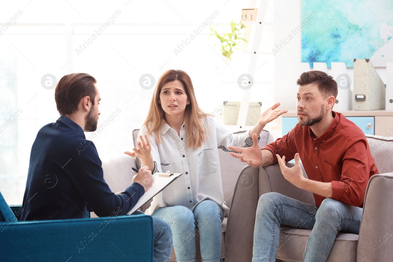 Photo of Family psychologist working with young couple in office