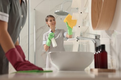 Professional chambermaids cleaning up bathroom in hotel