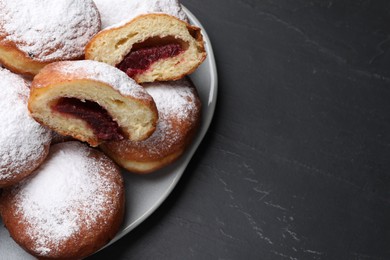 Photo of Delicious sweet buns with jam on dark gray table, top view. Space for text