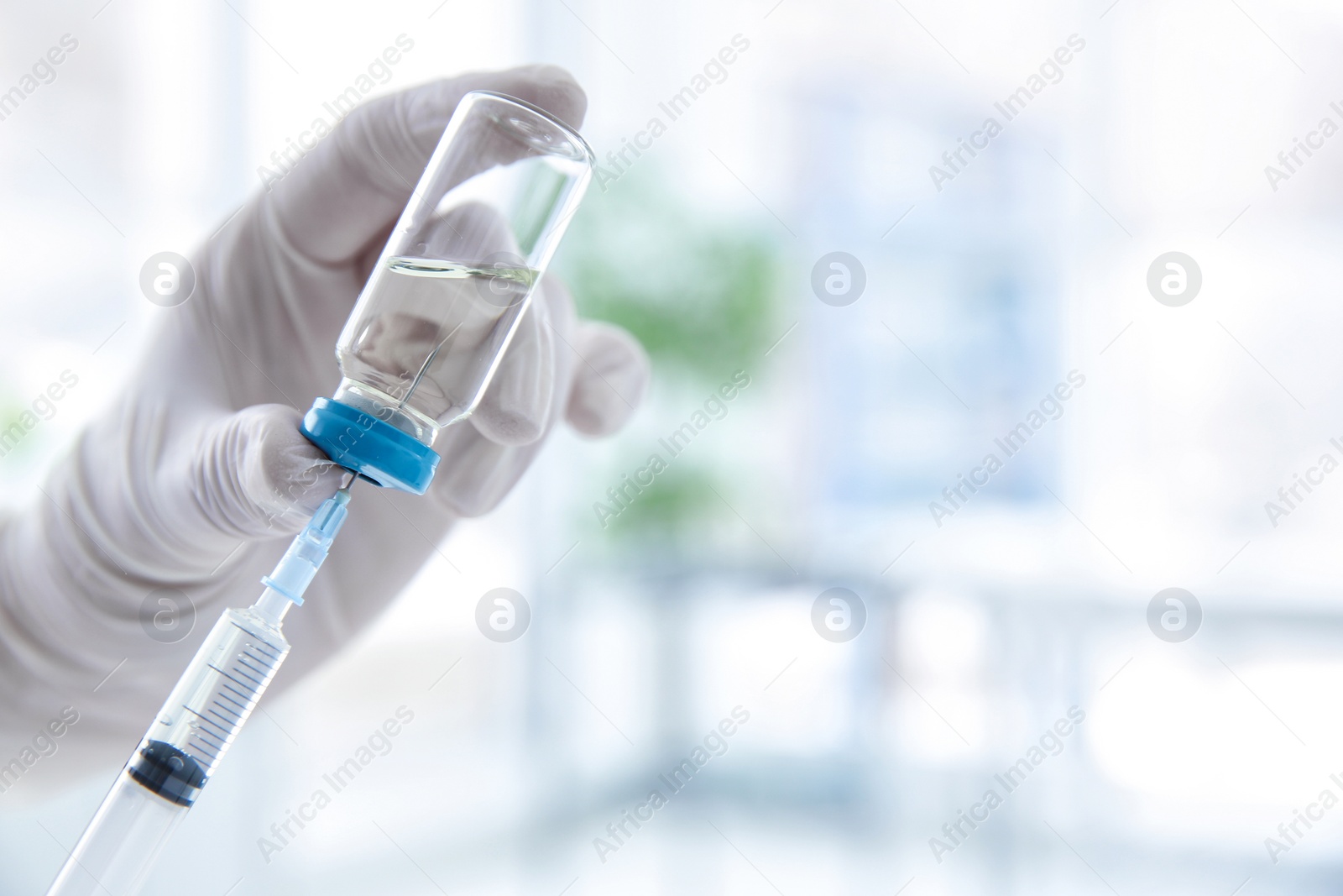 Photo of Doctor with syringe and medicine for vaccination on blurred background