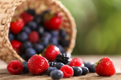 Photo of Different fresh ripe berries on wooden table outdoors, closeup