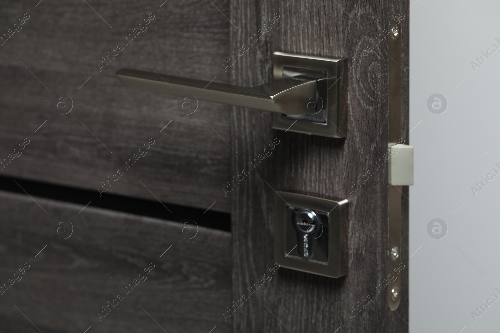 Photo of Open wooden door with metal handle, closeup