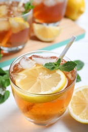 Photo of Delicious iced tea in glass on white table, closeup
