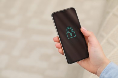 Woman holding smartphone with blocked screen indoors, closeup. Space for text