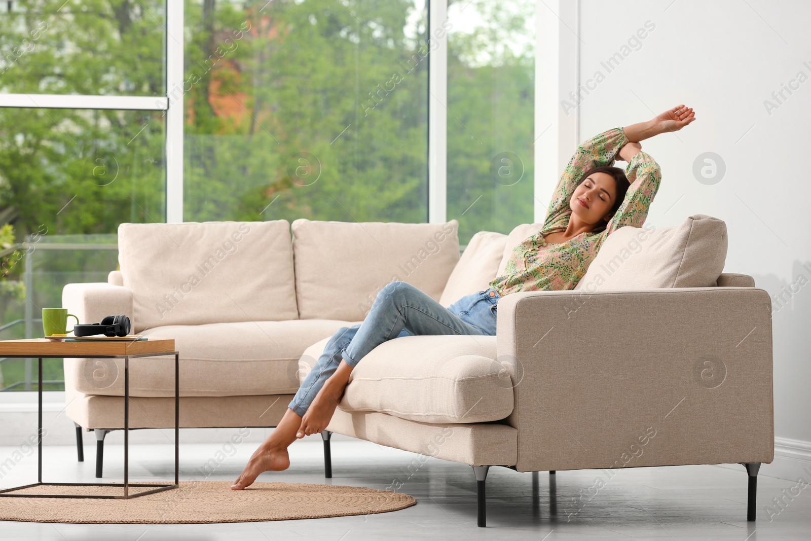 Photo of Young woman relaxing on sofa at home