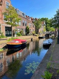Beautiful view of canal with moored boats in city on sunny day
