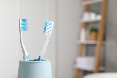 Photo of Plastic toothbrushes in holder on blurred background, closeup. Space for text