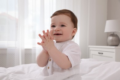 Photo of Happy baby boy on bed at home