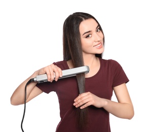 Happy woman using hair iron on white background