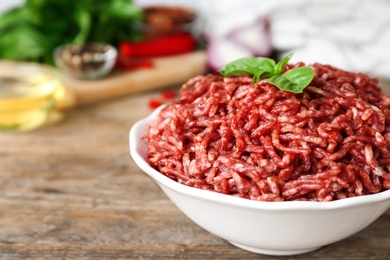 Fresh raw minced meat on wooden table, closeup