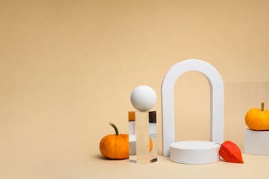 Photo of Autumn presentation for product. Geometric figures, pumpkins and physalis on beige background