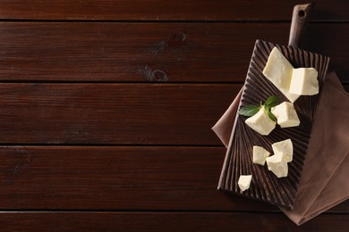 Photo of Pieces of tasty white chocolate and mint on wooden table, top view. Space for text