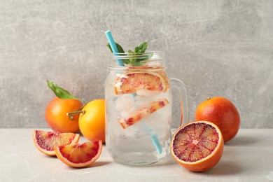 Photo of Delicious refreshing drink with sicilian orange and mint on grey table