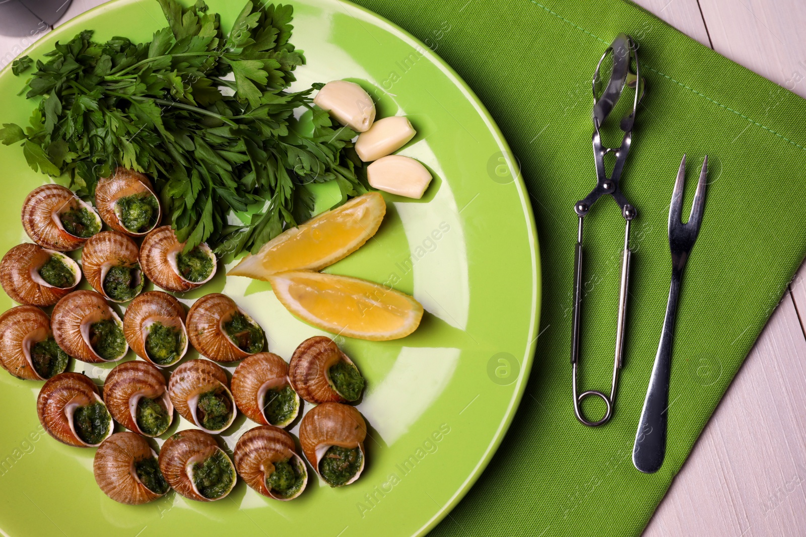 Photo of Delicious cooked snails served on white table, flat lay