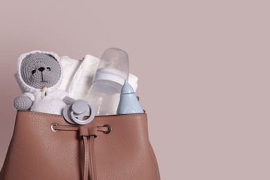 Photo of Mother's bag with baby's stuff on gray background, space for text
