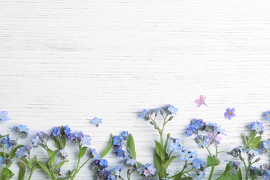 Photo of Amazing spring forget-me-not flowers and space for text on white wooden background, flat lay