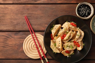 Photo of Delicious gyoza (asian dumplings) served on wooden table, flat lay