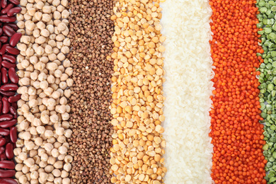 Photo of Different types of legumes and cereals as background, top view. Organic grains