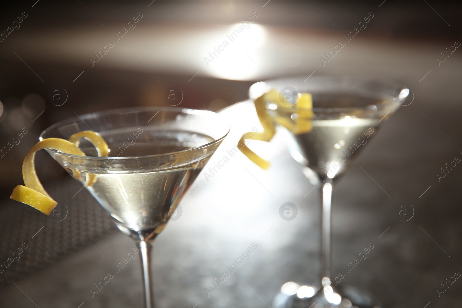 Photo of Glasses of lemon drop martini cocktail in bar, closeup. Space for text