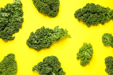 Photo of Fresh kale leaves on yellow background, flat lay