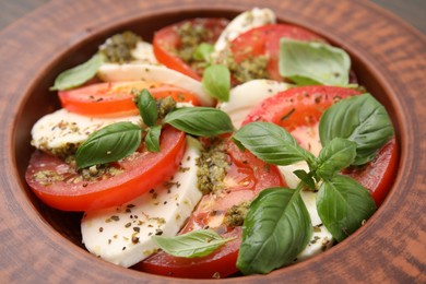 Photo of Delicious Caprese salad with pesto sauce in plate, closeup