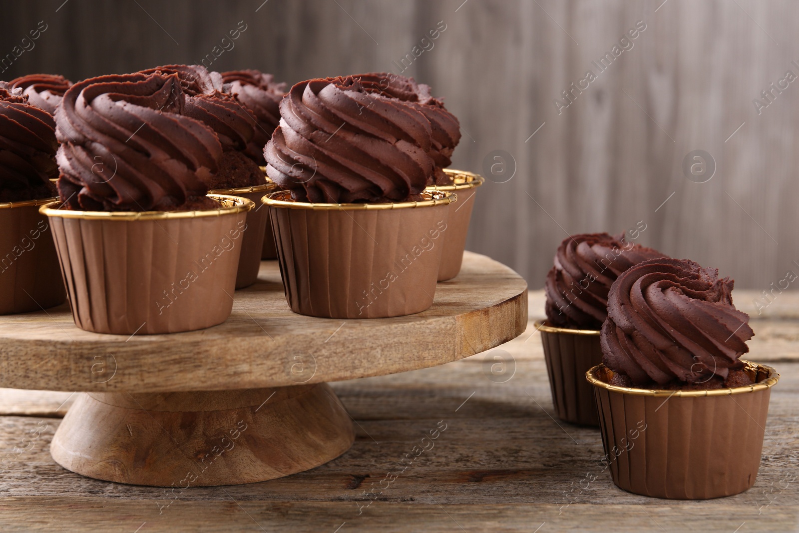 Photo of Delicious chocolate cupcakes on wooden table. Sweet desserts