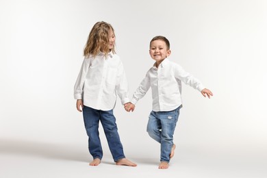 Photo of Cute little children on white background. Happy family