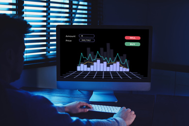 Broker using computer in dark room. Forex trading