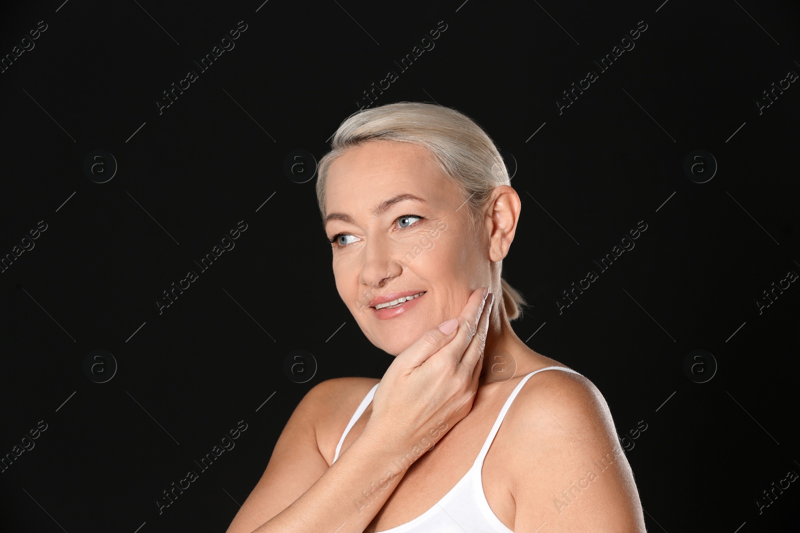 Photo of Portrait of beautiful mature woman on black background