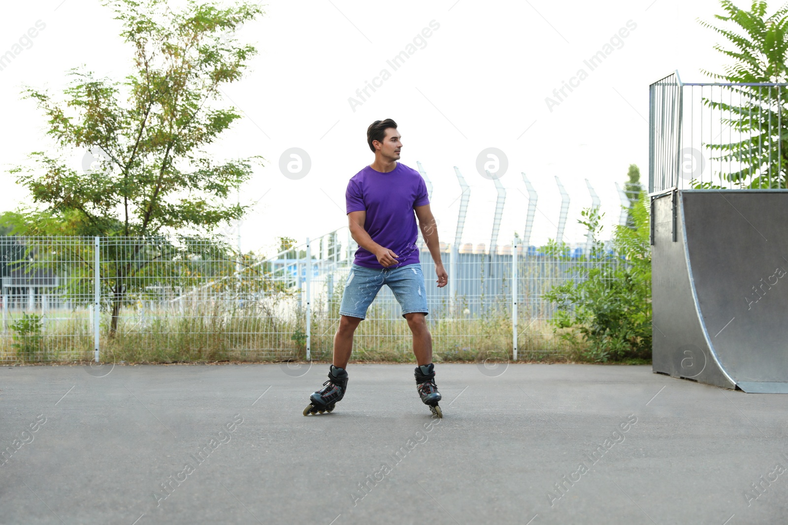 Photo of Handsome young man roller skating in park