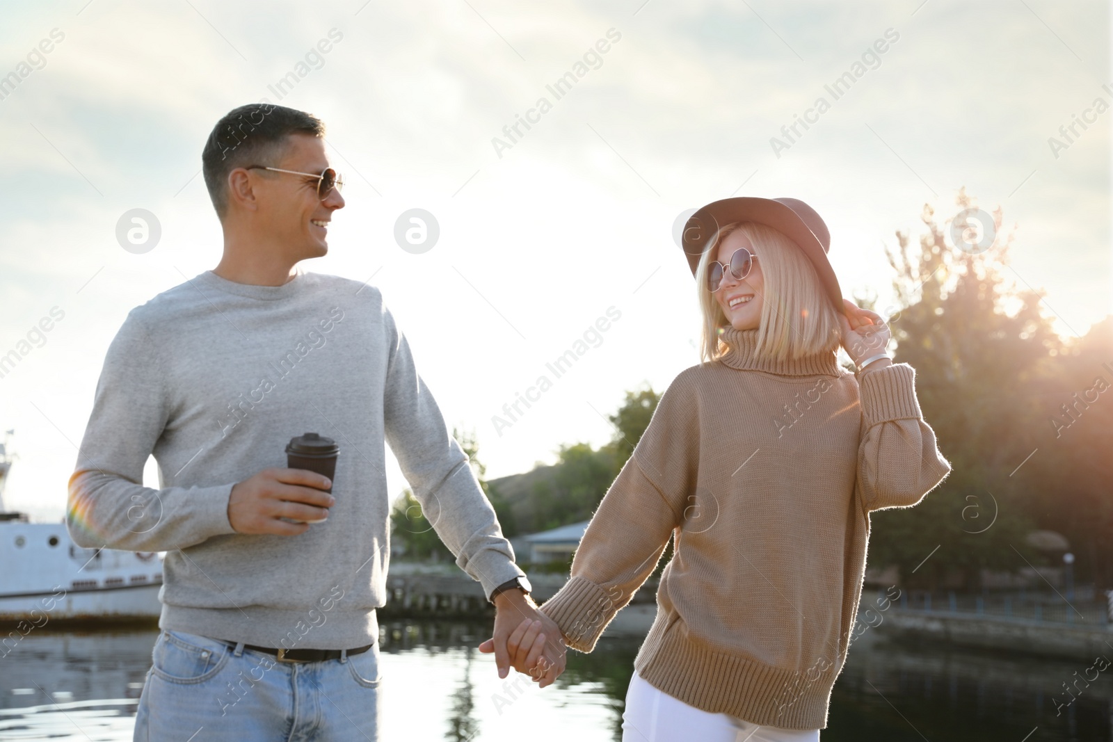 Photo of Couple in stylish sweaters on city pier