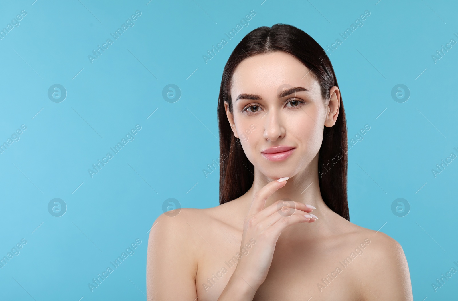 Photo of Portrait of beautiful young woman on light blue background. Space for text