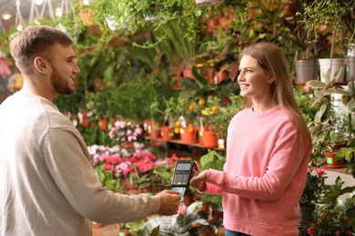 Client using credit card for terminal payment in floral shop