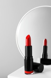 Photo of Beautiful red lipstick on light gray background