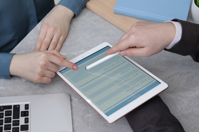 Image of Electronic signature. Woman using tablet at table, closeup