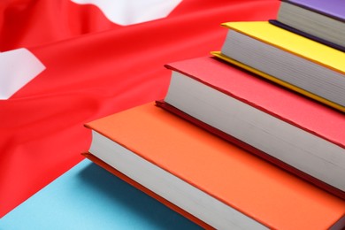 Photo of Learning foreign language. Different books on flag of United Kingdom, closeup