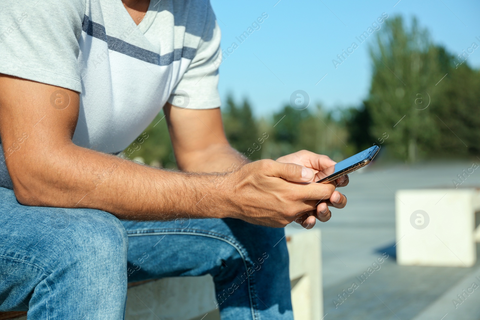 Photo of Man using modern mobile phone outdoors, closeup