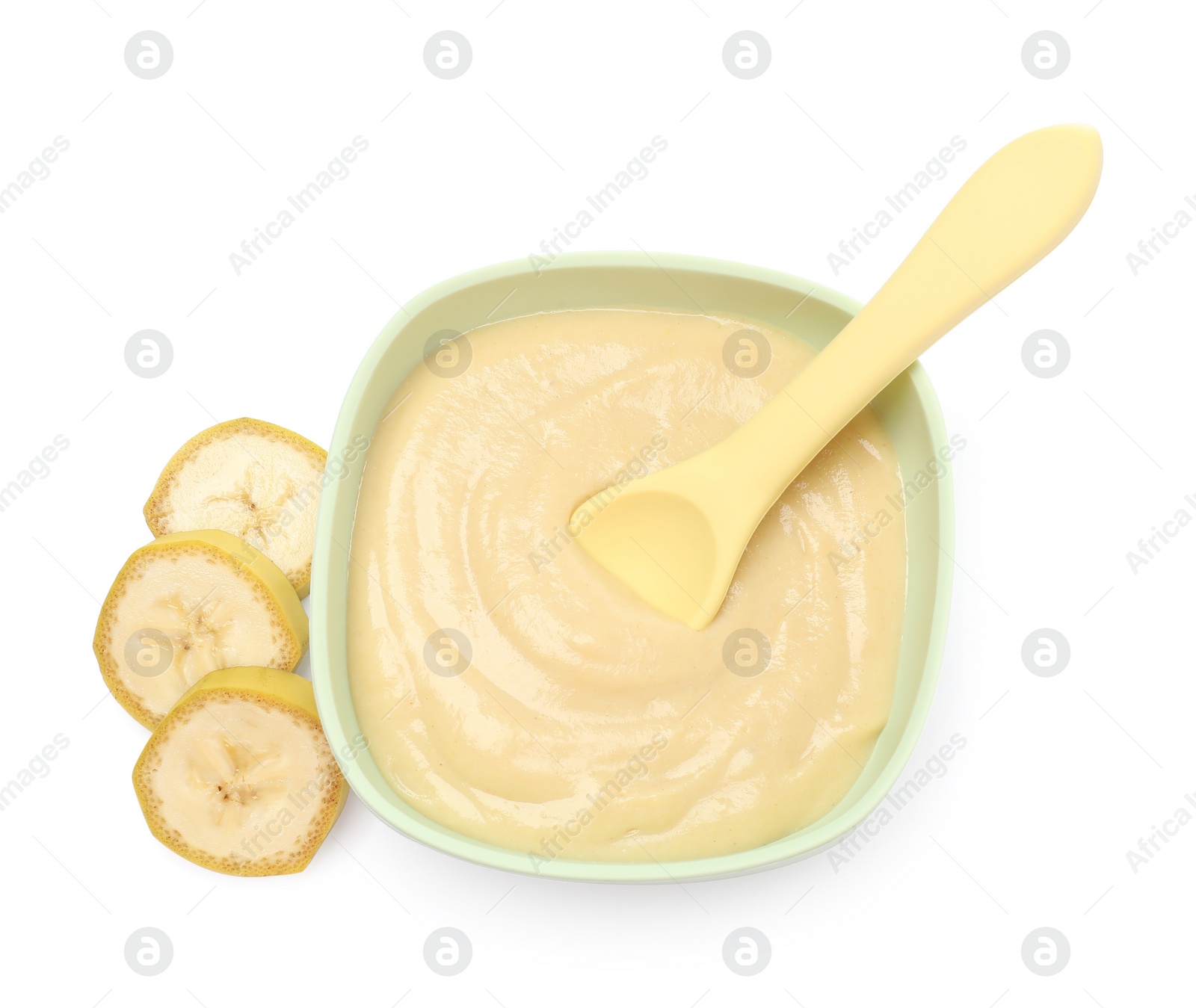 Photo of Tasty baby food in bowl, spoon and cut banana isolated on white, top view