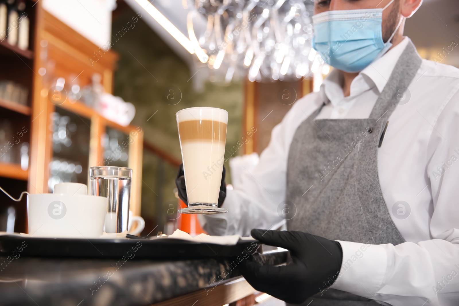 Photo of Waiter serving beverages in restaurant, closeup. Catering during coronavirus quarantine