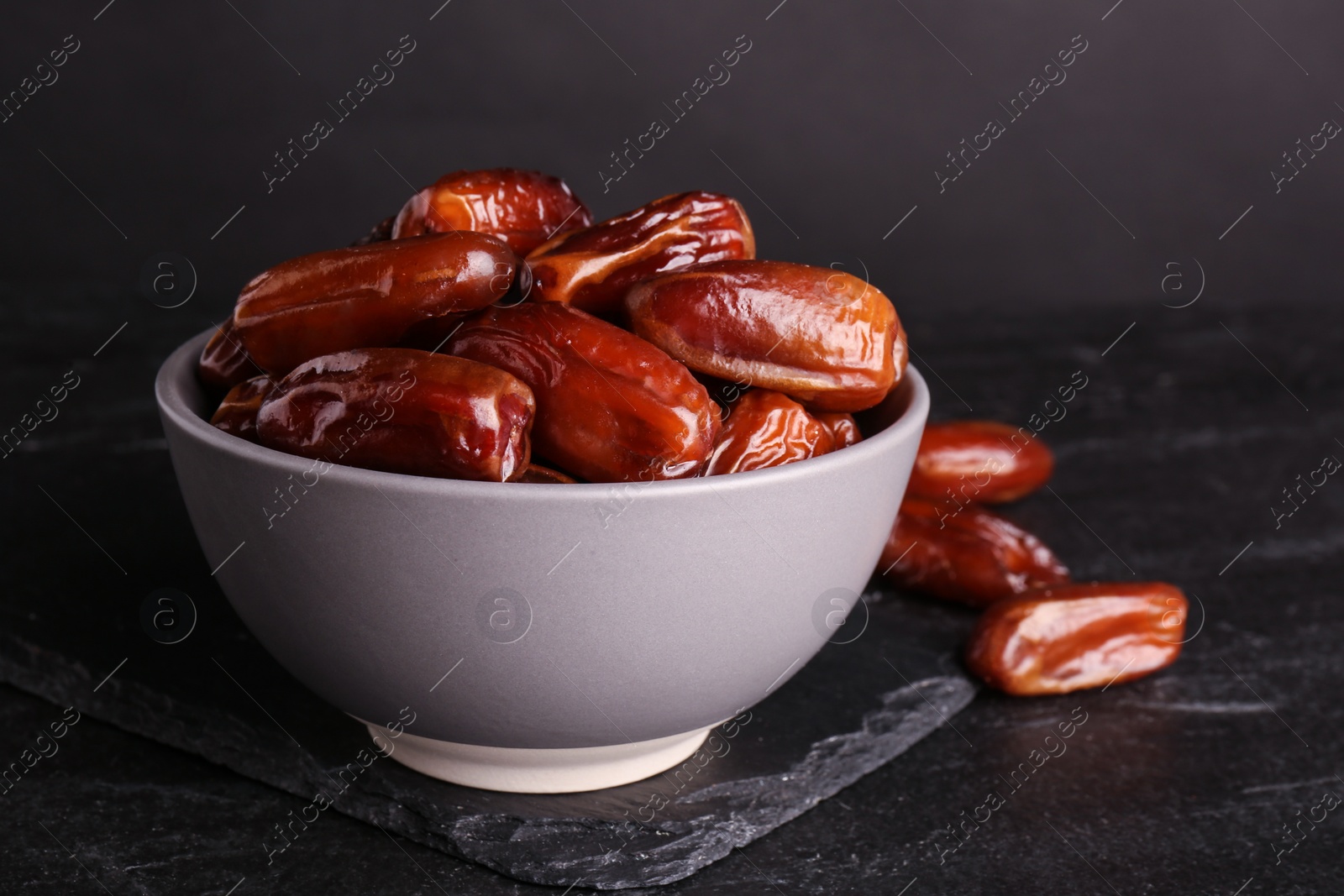 Photo of Tasty sweet dried dates on black table