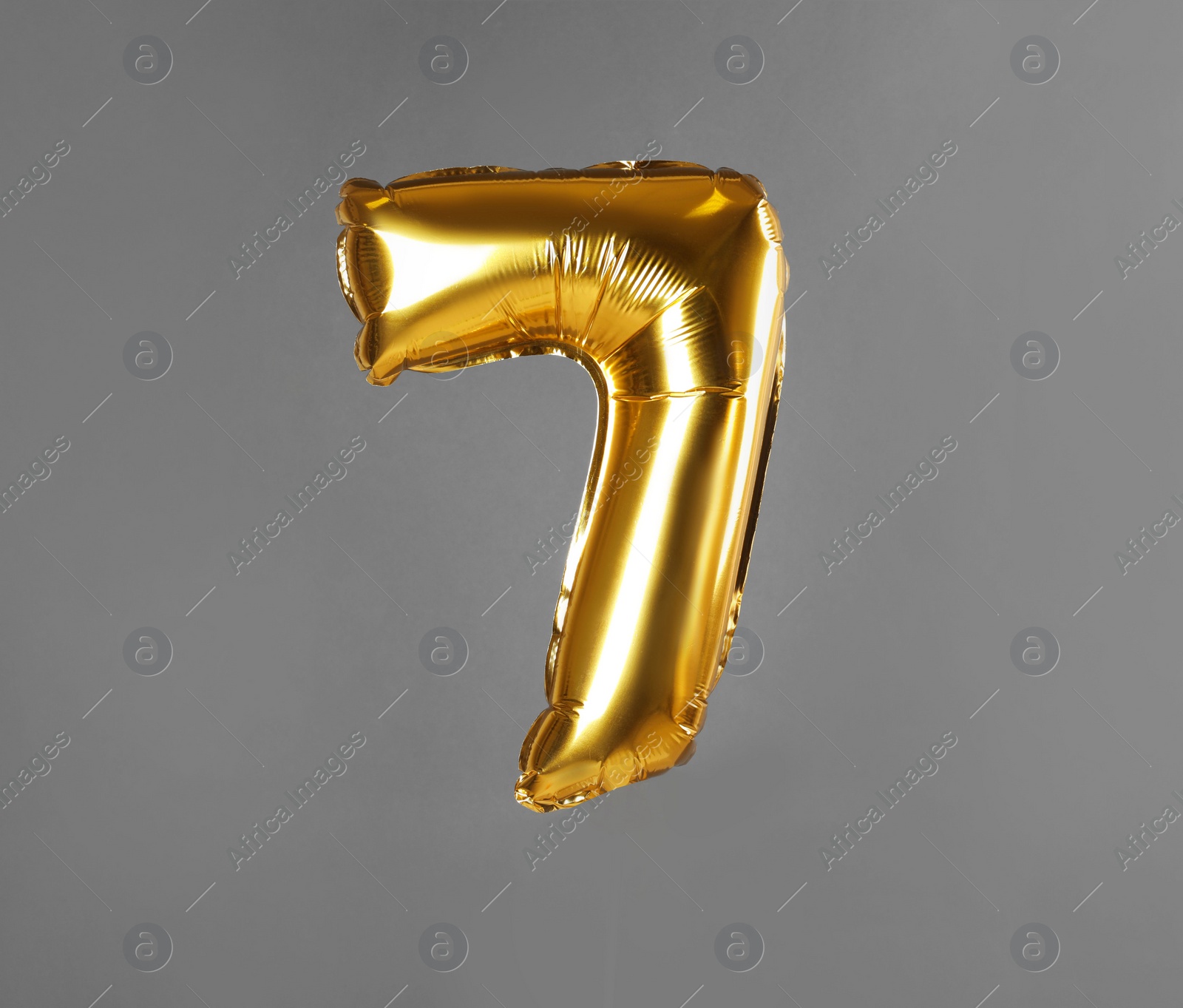Photo of Golden number seven balloon on grey background