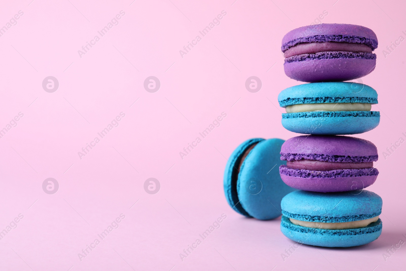 Photo of Stack of delicious colorful macarons on pink background. Space for text