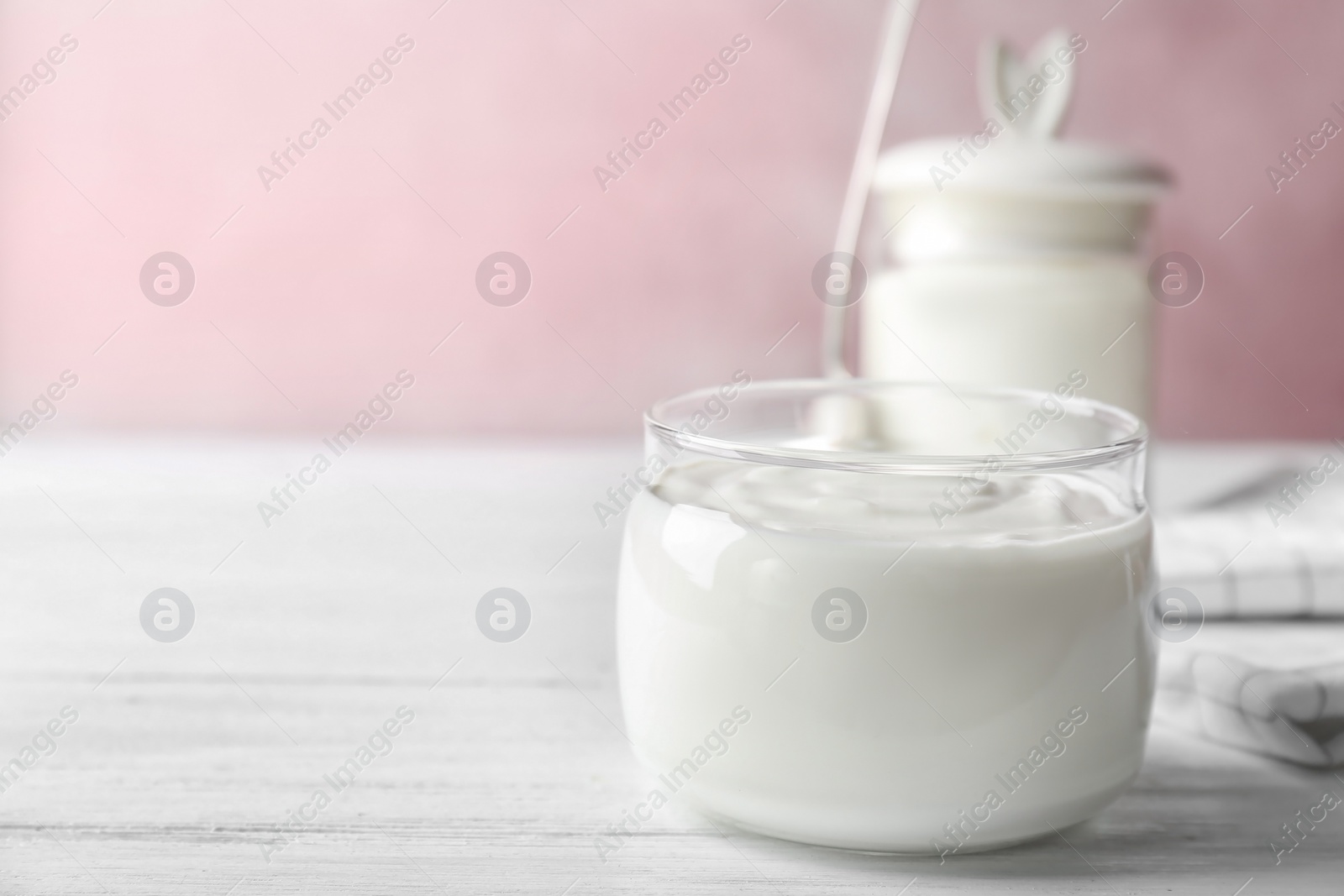 Photo of Glass jar tasty with yogurt on wooden table