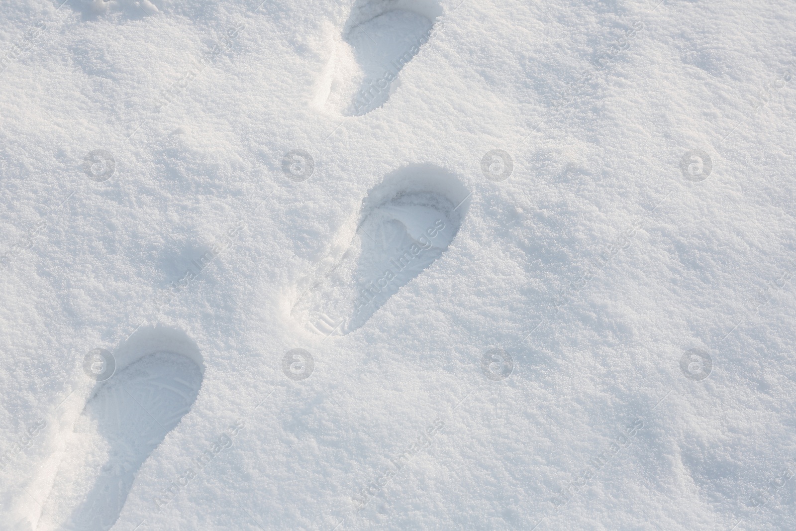 Photo of Footprints on white snow outdoors. Winter season